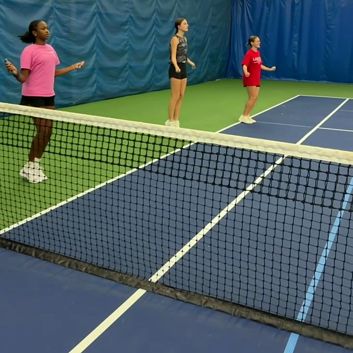 Junior players doing a footwork drill at the net