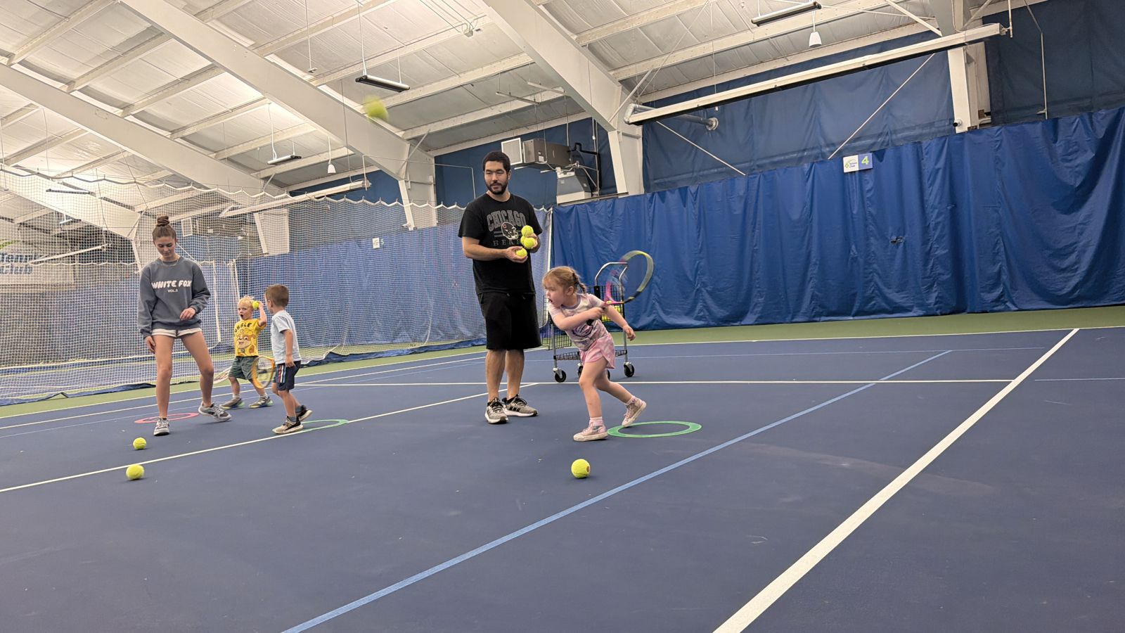 Coaches leading a youth tennis class on the indoor courts at the Quad City Tennis Club