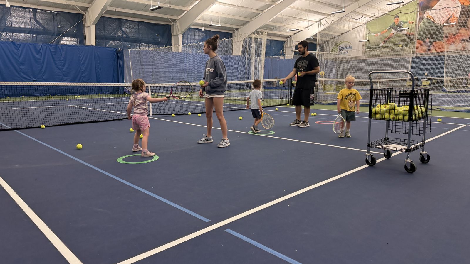 Coaches working with young players during a class on the indoor courts